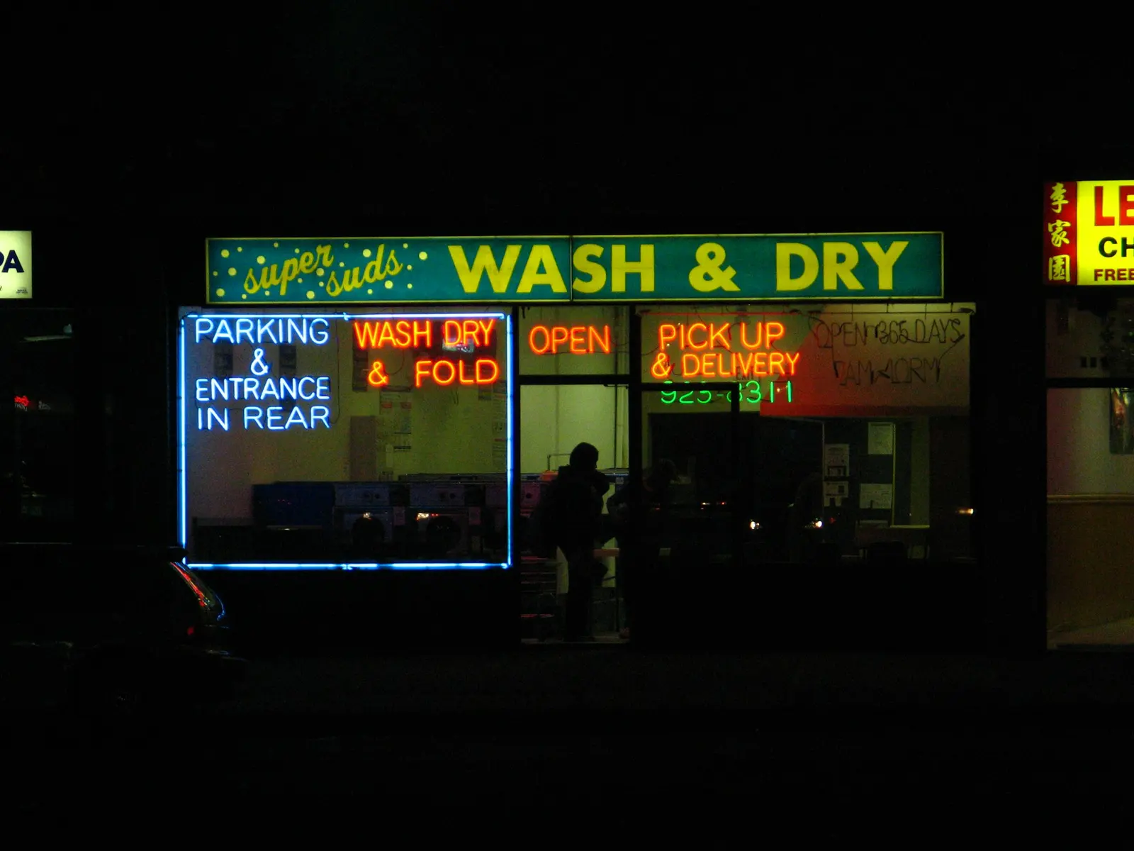 A neon Wash & Dry laundromat sign at night
